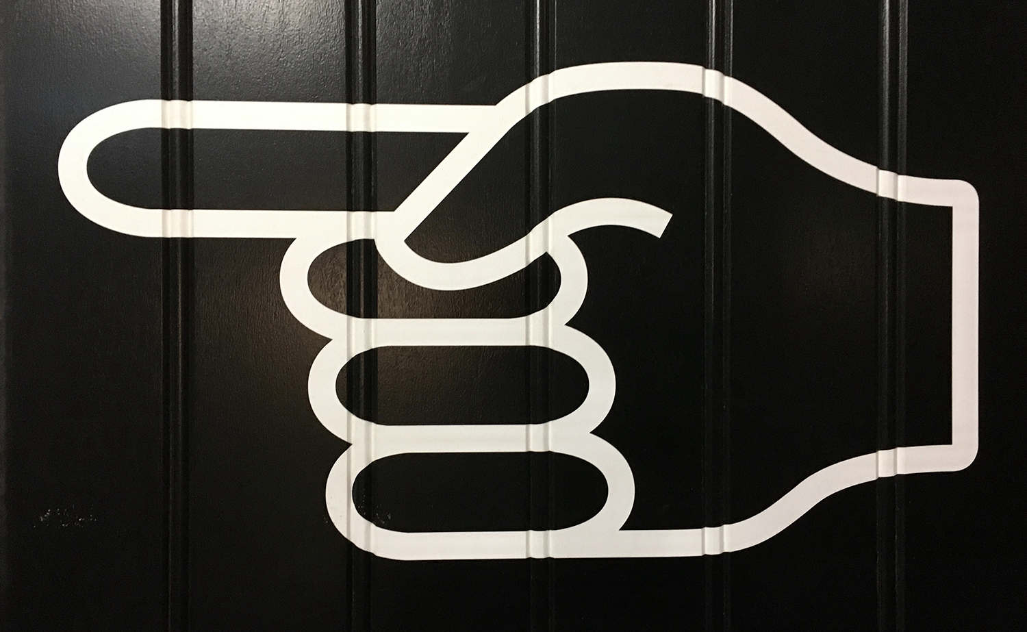Large bold outline of a hand point to the left.